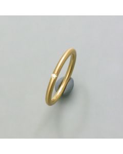 Delicate gold ring with diamond in round profile